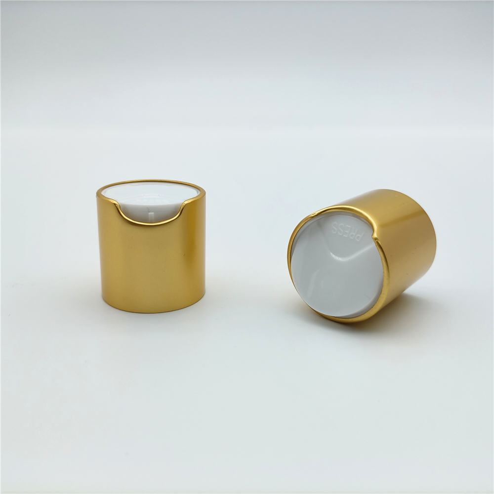 Two gold cosmetic pump caps with white press tops on a white background.
