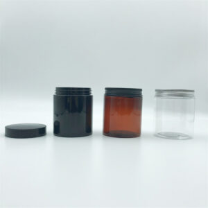Empty plastic jars in black, amber, and clear colors with screw lids.