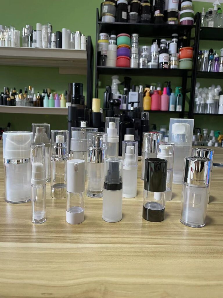 Various empty airless pump bottles for skincare and cosmetic packaging on wooden table.
